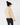 Parchment women’s fleece golf jacket with contrast side panels, shown from the back with a black bobble hat.