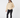 A woman modeling a beige sherpa zip-up jacket, black skinny pants, a black knit beanie, and beige Chelsea boots.