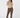 A woman modeling a beige and brown geometric patterned mock-neck long-sleeve top paired with brown trousers and patterned socks.