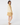 Woman modeling a caramel and parchment ribbed knit top with a caramel golf skort, shown from the back.