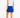 A woman is shown from the back wearing a blue patterned collar and a bright blue golf skort with a small white star logo and text on the back side. Paired with a sleeveless white top and white sneakers.