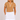 A woman in a tan short-sleeve golf top with white polka dots and white trim, paired with a white mini skirt.