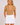 A woman in a tan short-sleeve golf top with white polka dots and white trim, paired with a white mini skirt.