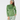 A woman modeling a green long-sleeve quarter-zip athletic top with a matching green and white patterned headband and matching patterned leggings.