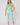 Model wearing the Alice Sleeveless Top in Dazzling Blue & Emerald paired with patterned capri pants